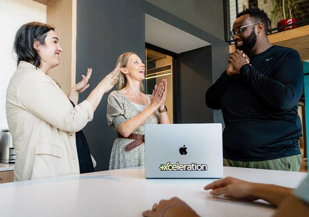Coworkers applauding a colleague during a team meeting